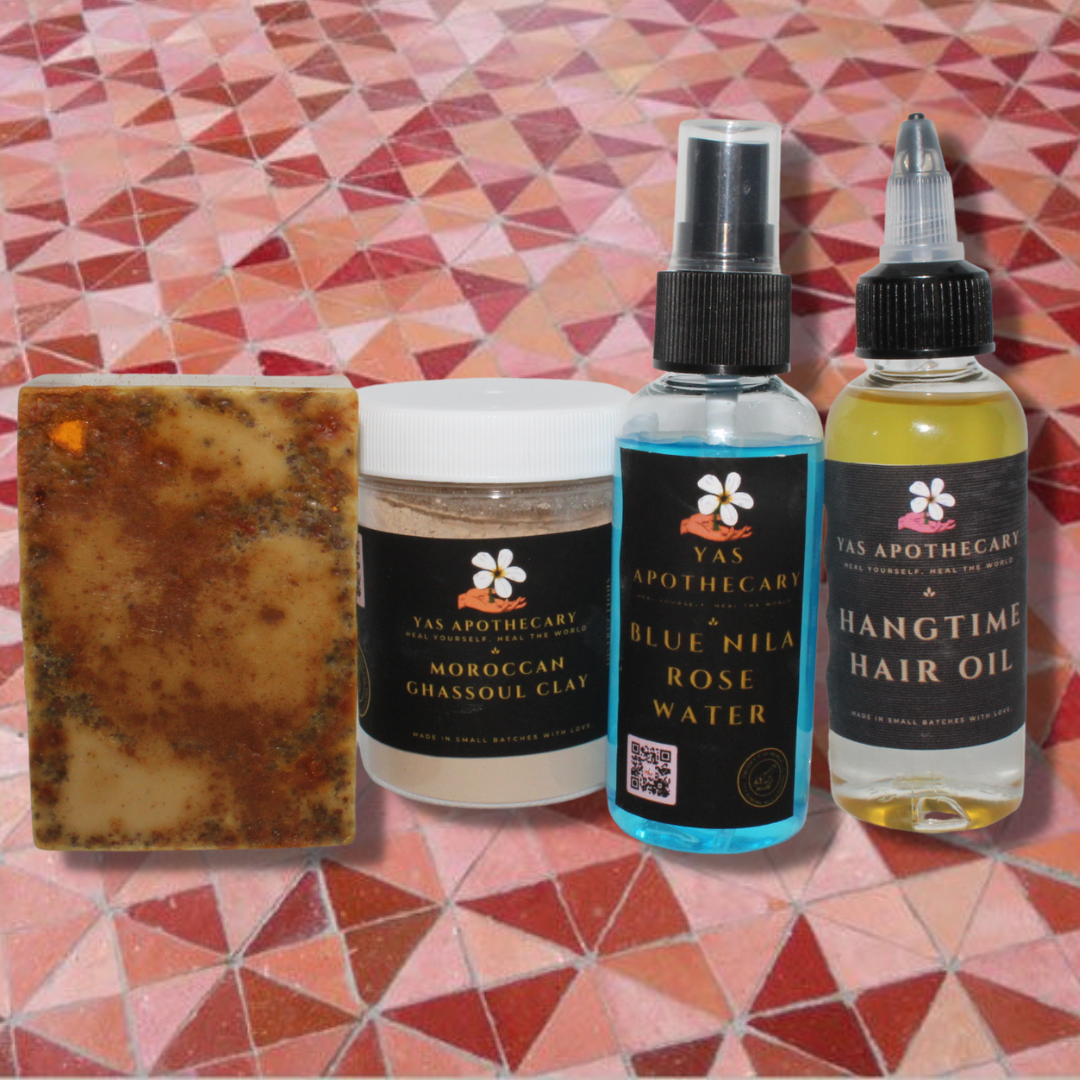 (From left to right) The Top of the Morning Turmeric Bar Soap, a container of Moroccan Ghassoul Clay Mask, one bottle of the Blue Nila Rose Water and the Hangtime Hair Oil are lined up next to each other.