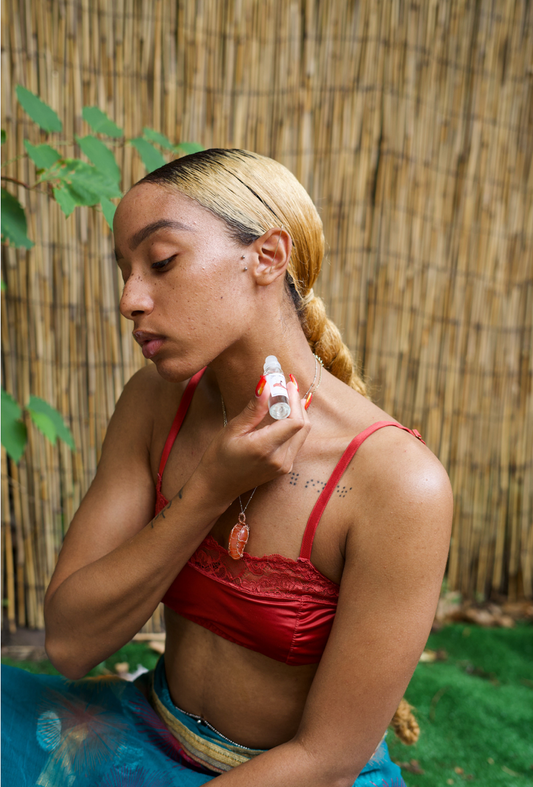 Female model applying perfume on to her neck