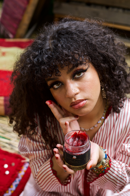 Female Model holding an opened jar of the soap